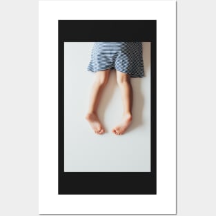 Legs of Small Girl Lying on White Tabletop Posters and Art